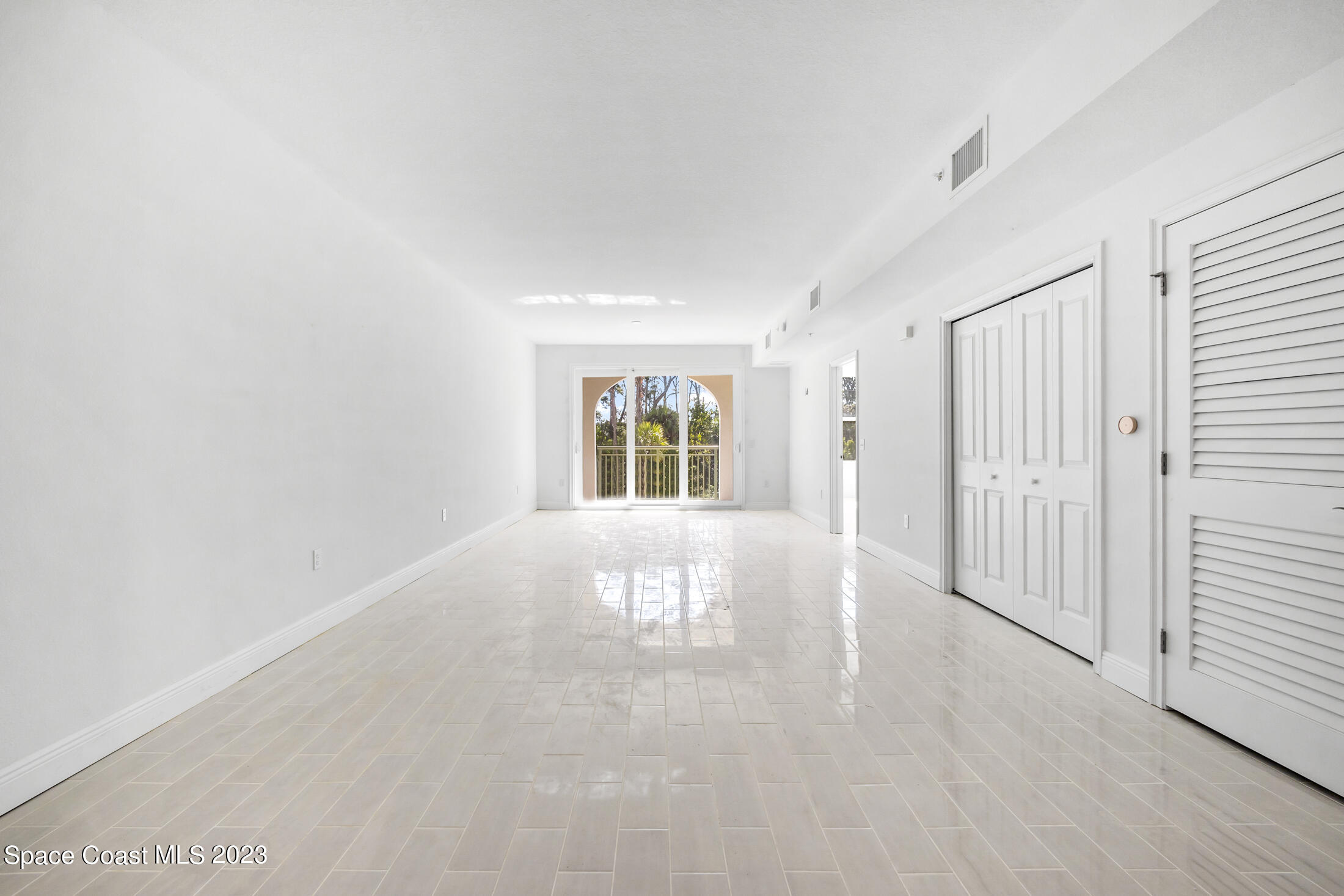 735 Pilot Lane, Unit 313 Merritt Island, FL 32952 - Photo 3 of 20 an empty room with wooden floor and windows