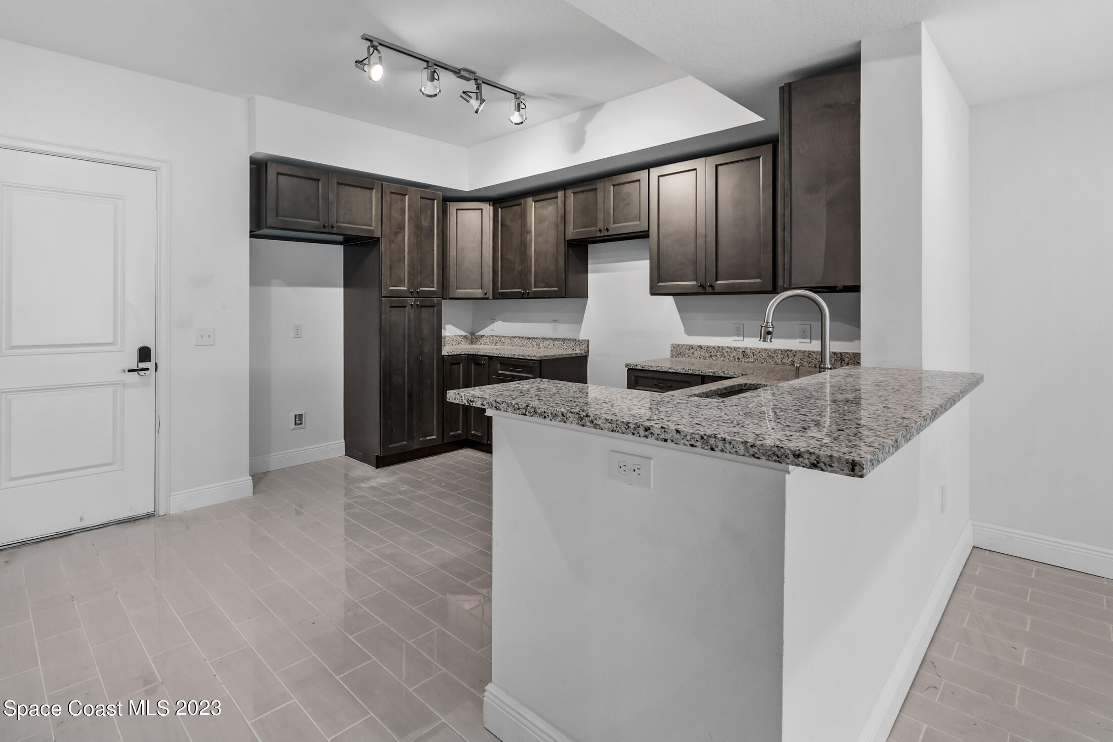 735 Pilot Lane, Unit 313 Merritt Island, FL 32952 - Photo 4 of 20 a kitchen with stainless steel appliances granite countertop a refrigerator a sink and a stove