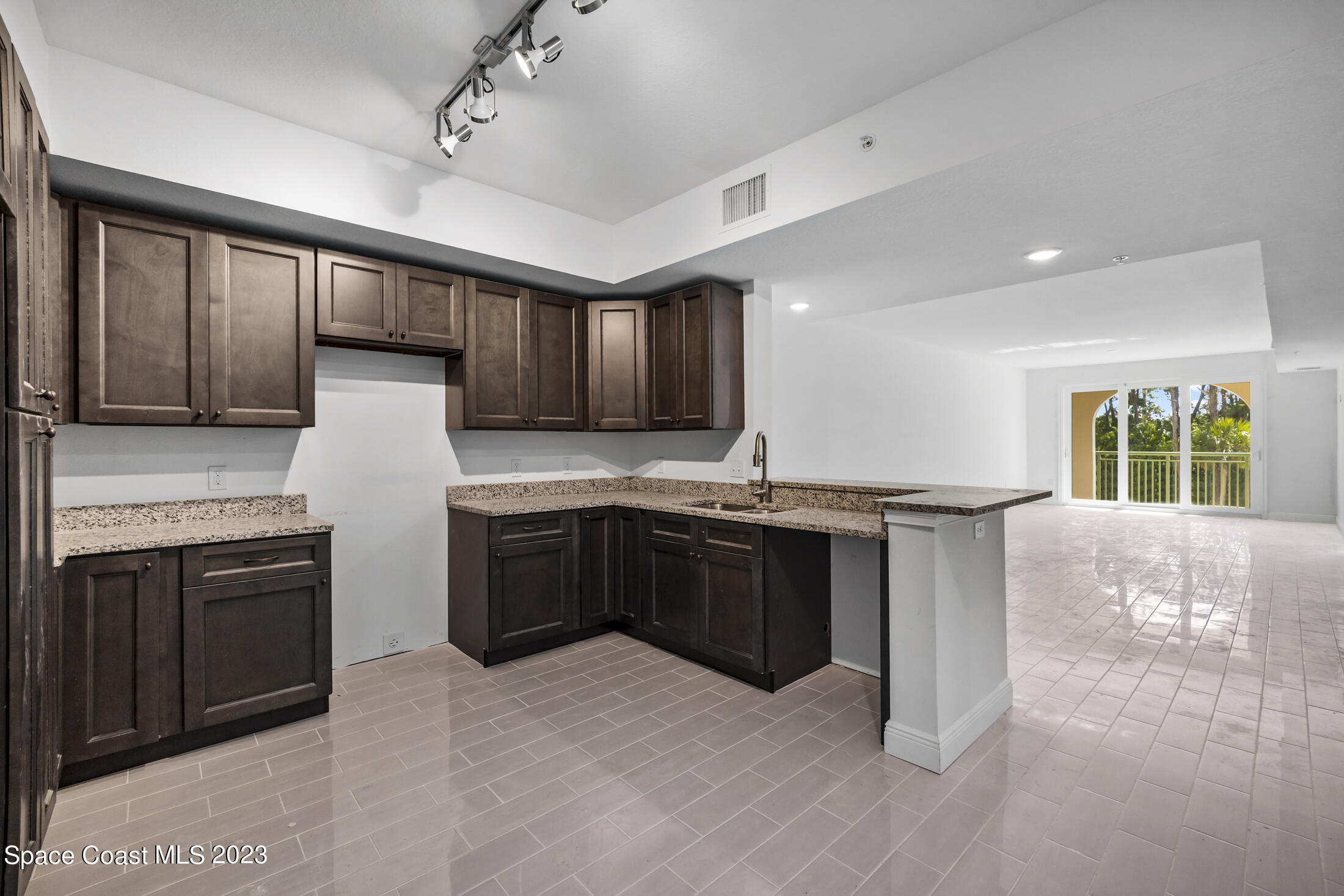 735 Pilot Lane, Unit 313 Merritt Island, FL 32952 - Photo 5 of 20 a kitchen with stainless steel appliances granite countertop a stove sink and cabinets