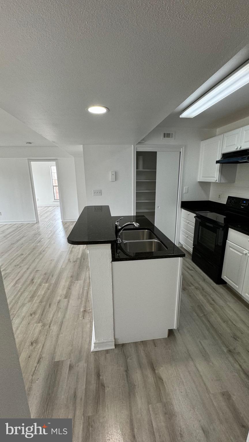 12151 Penderview Lane, Unit 2038 Fairfax, VA 22033 - Photo 4 of 18 a living room with stainless steel appliances kitchen island granite countertop a refrigerator a stove top oven and wooden floor