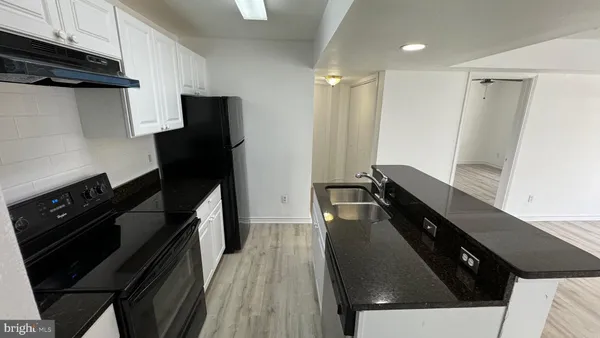 a kitchen with a sink and wooden floor