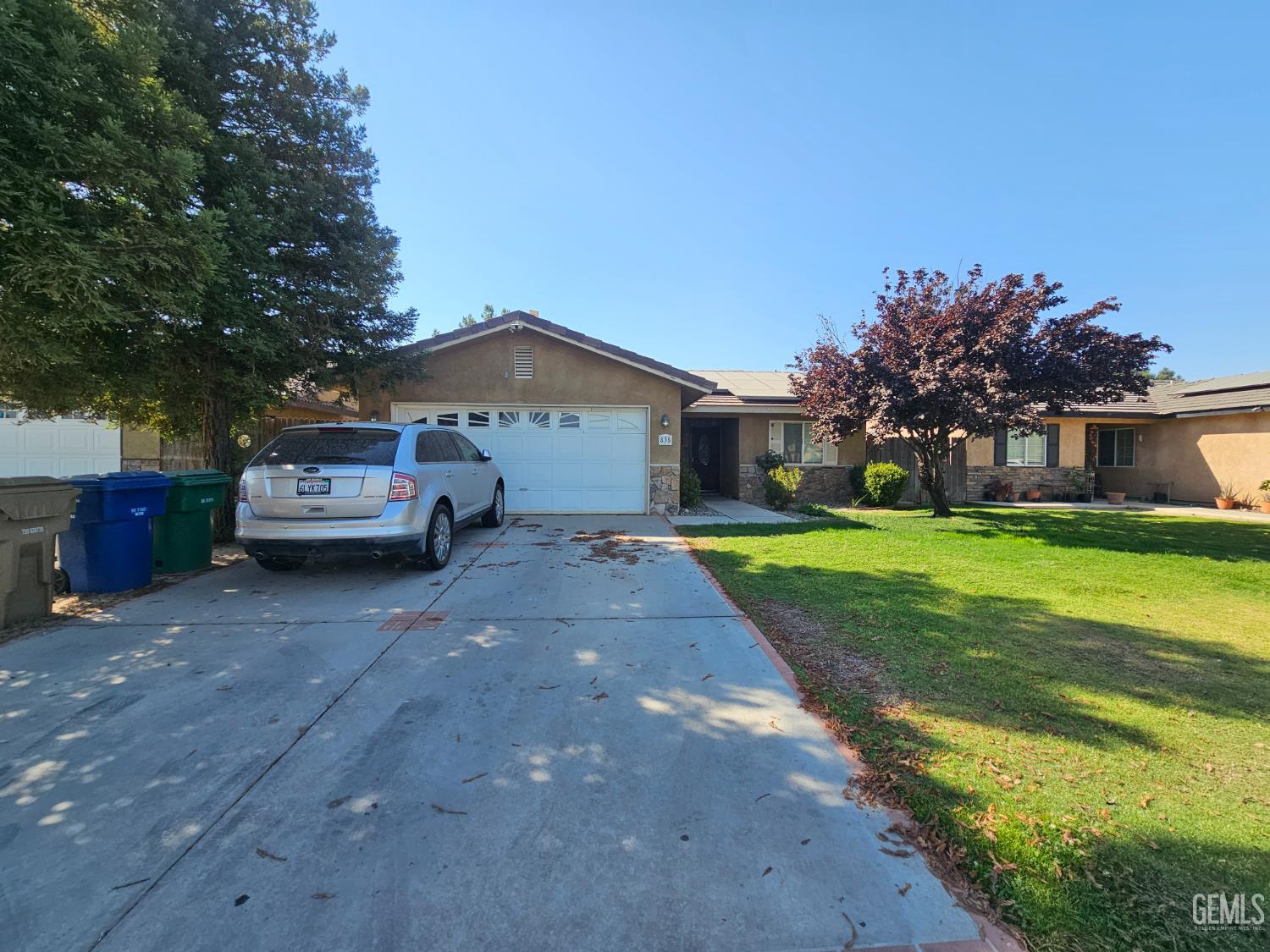 Undisclosed Address Bakersfield, CA 93308 - Photo 2 of 11 a car parked in front of house with a yard