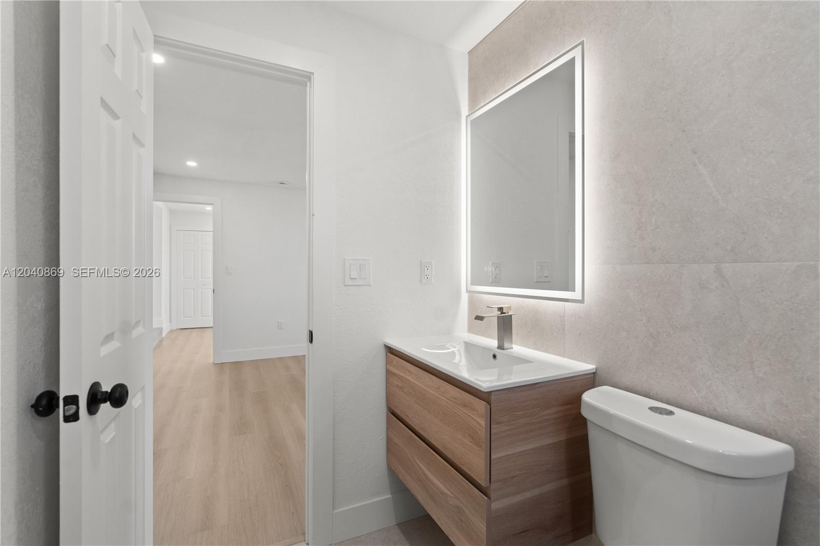 31 West 64th Street Hialeah, FL 33012 - Photo 34 of 49 a bathroom with a toilet sink and mirror