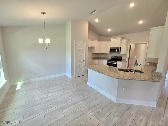 a large kitchen with kitchen island a large counter top and appliances