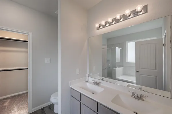 a bathroom with a sink a toilet a light fixture and a mirror