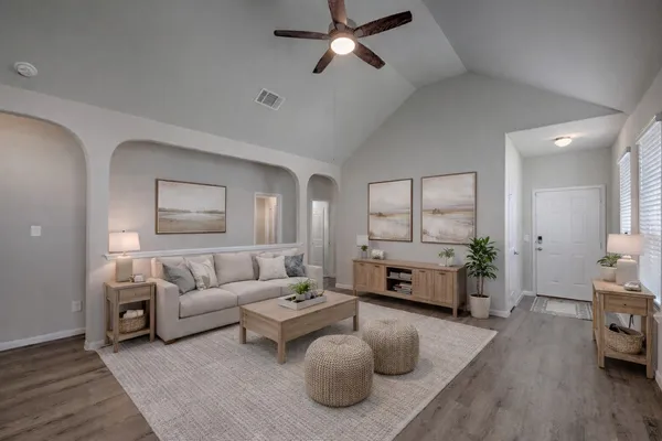 a living room with furniture and a wooden floor
