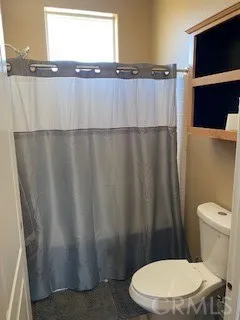 a white toilet sitting next to a small window
