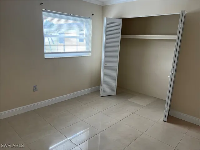 an empty room with windows and closet