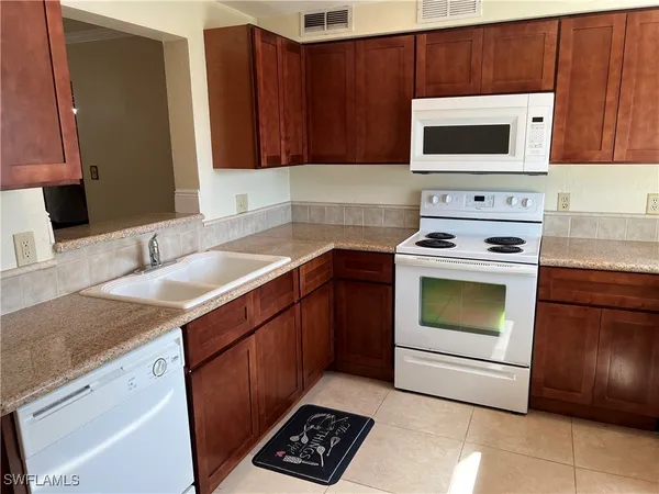 a kitchen with granite countertop a stove top oven microwave and cabinets
