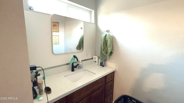 a bathroom with a granite countertop sink mirror vanity and toilet