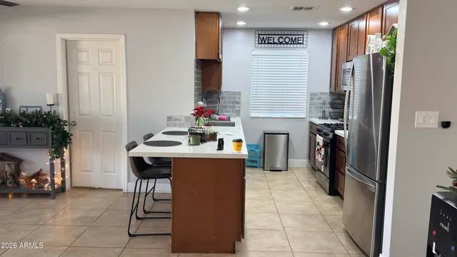 a kitchen with stainless steel appliances a refrigerator a sink a stove and island