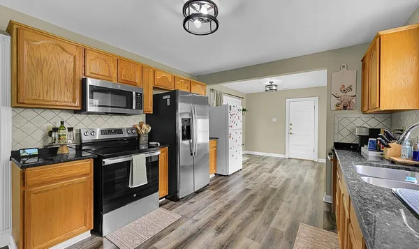 a kitchen with stainless steel appliances granite countertop a refrigerator stove top oven a sink and dishwasher