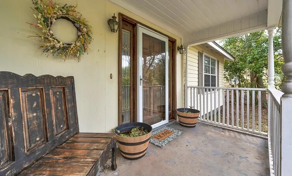 a view of a porch with furniture and floor to ceiling window