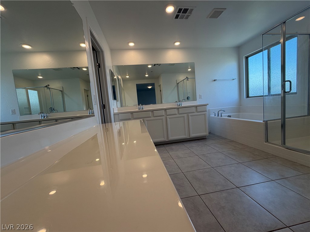 3228 Azalea Ridge Court Henderson, NV 89052 - Photo 10 of 28 A well-lit primary bathroom features dual vanities, a separate tub, and a glass-enclosed shower.