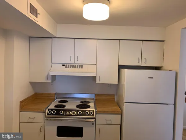 a kitchen with cabinets and white stainless steel appliances