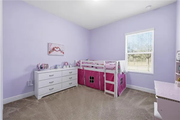 a view of a bedroom with a bed and window