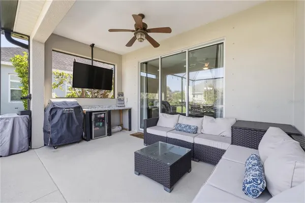 a living room with furniture a flat screen tv and a large window
