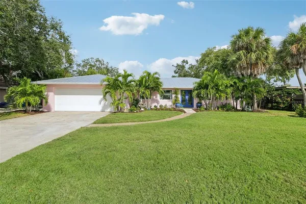 a front view of a house with a yard and trees
