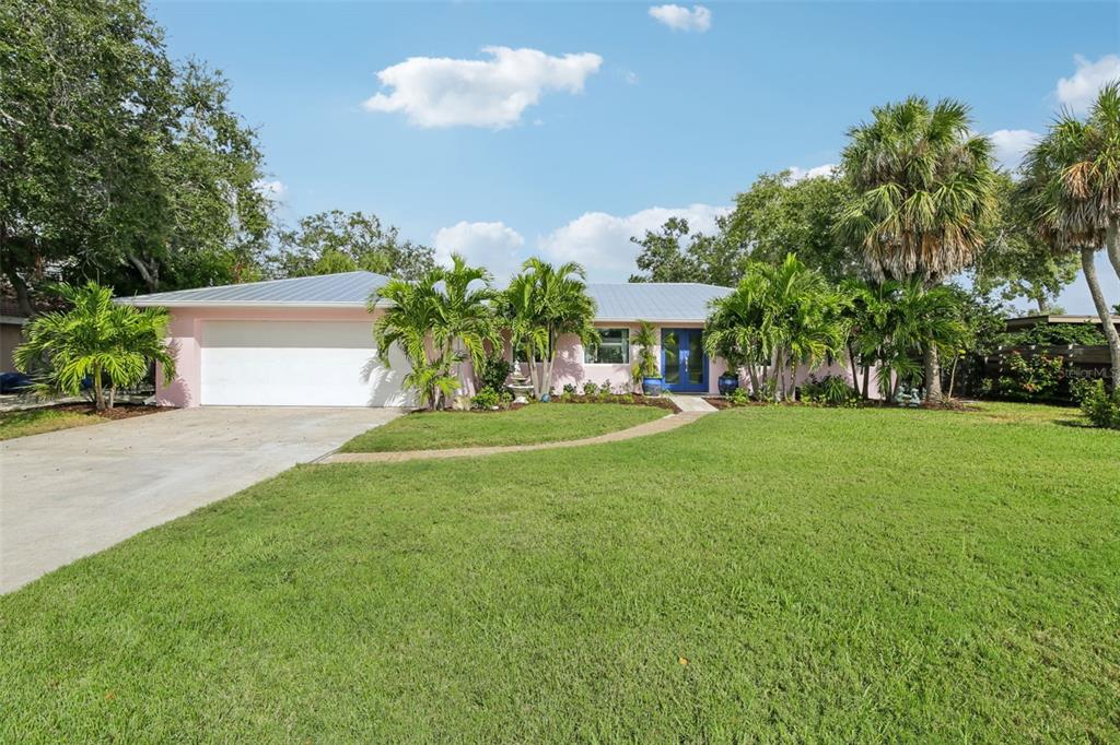 a front view of a house with a yard and trees