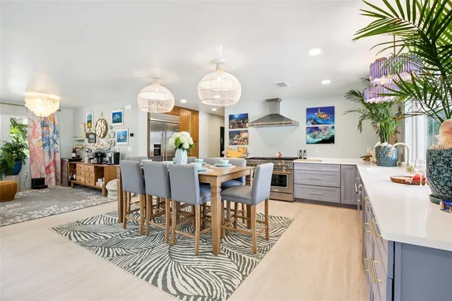 a living room with furniture a chandelier and a dining table