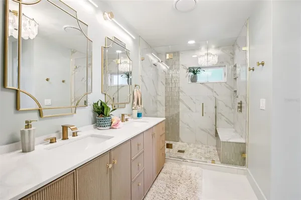 a bathroom with a double vanity sink mirror and shower