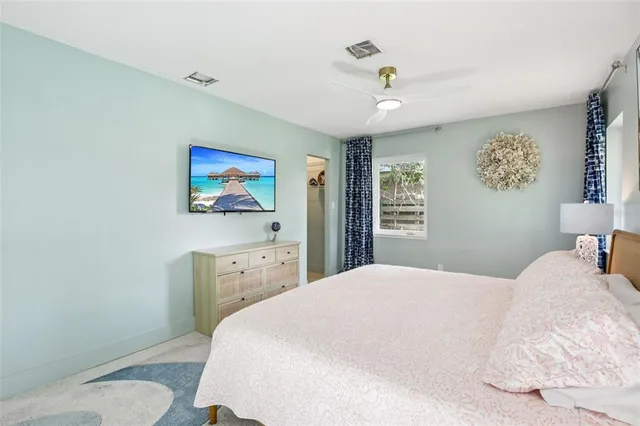 a bedroom with a large bed and a chandelier