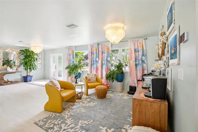 a living room with patio furniture and a potted plant