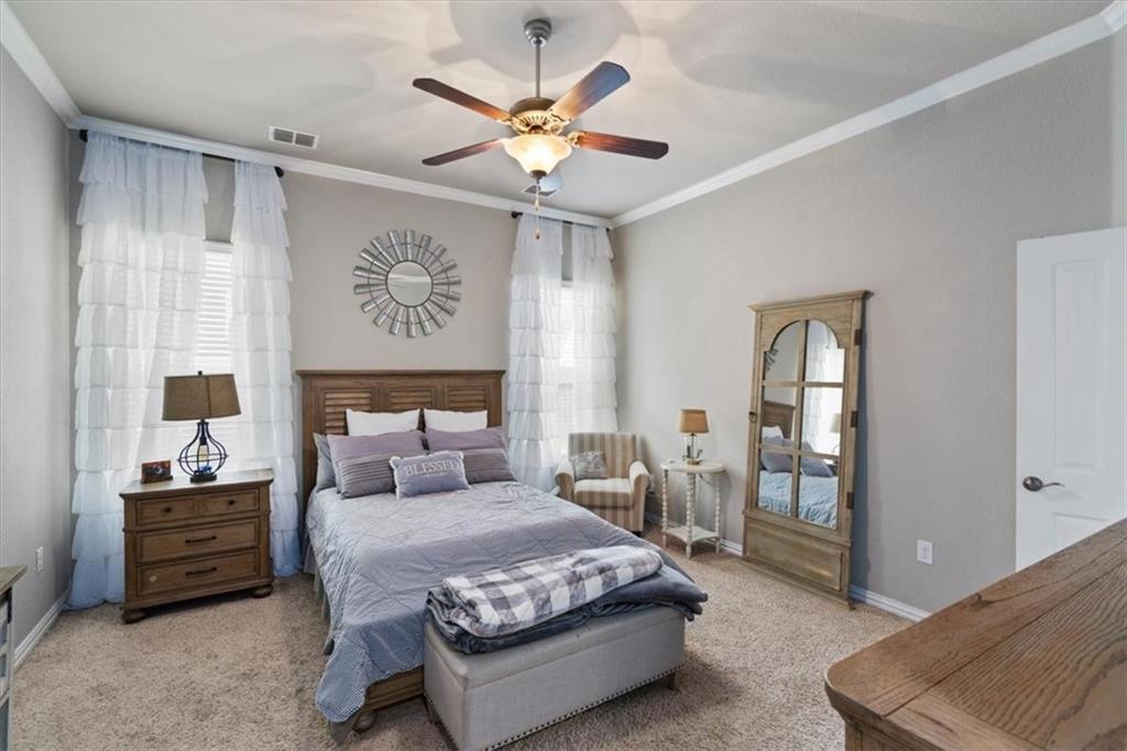 12311 Altamira Street Austin, TX 78748 - Photo 13 of 36 a bedroom with a large bed and a chandelier