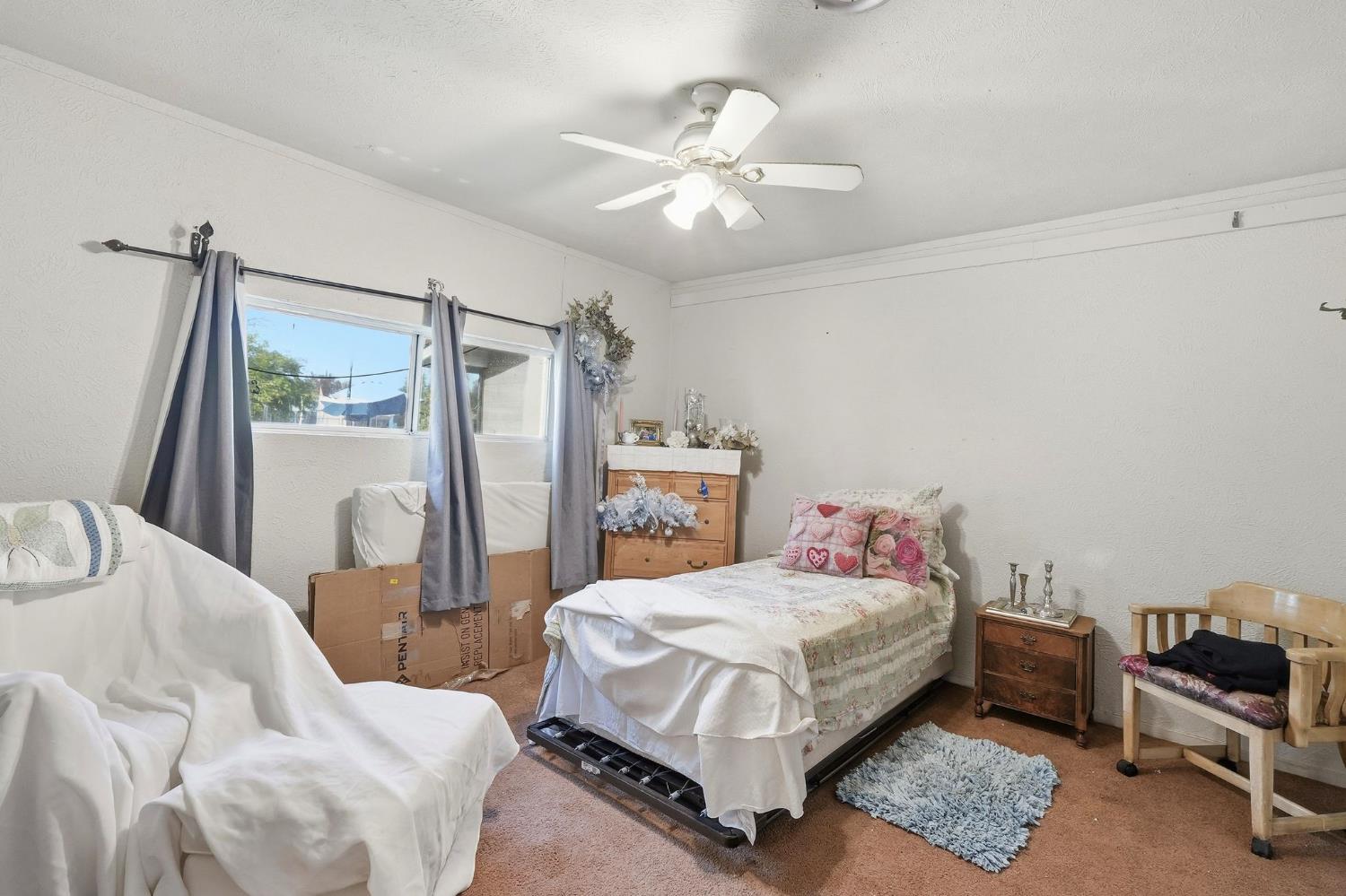7801 El Modena Avenue Elverta, CA 95626 - Photo 19 of 51 a bedroom with a bed a chandelier and a dresser
