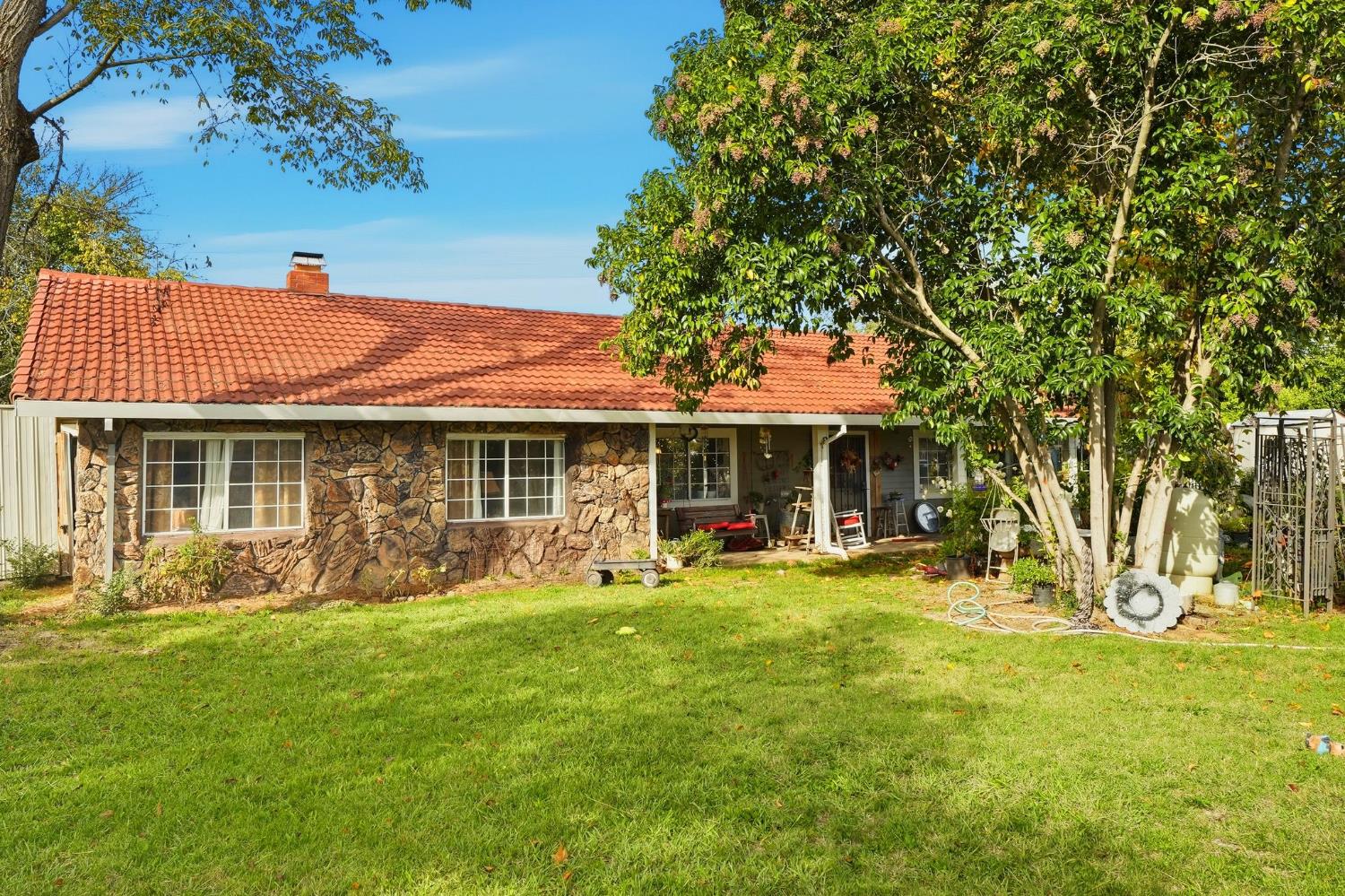 7801 El Modena Avenue Elverta, CA 95626 - Photo 3 of 51 a front view of a house with a garden and patio
