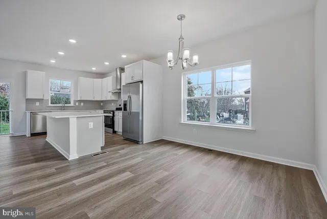 a kitchen with cabinets and wooden floor
