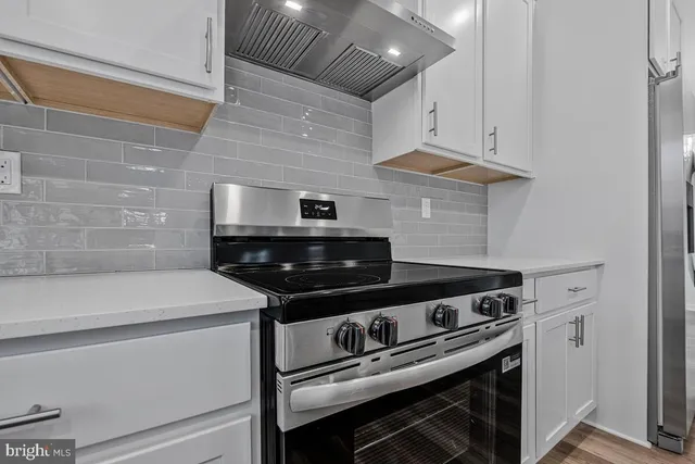 a kitchen with white cabinets and stainless steel appliances