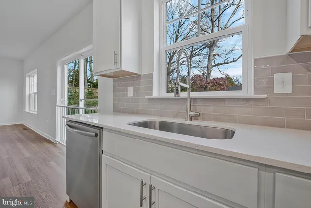 a large kitchen with stainless steel appliances granite countertop a stove a sink and a refrigerator