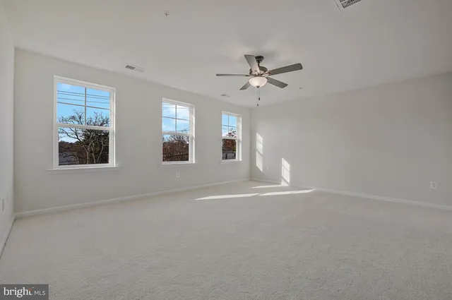 an empty room with windows and closet