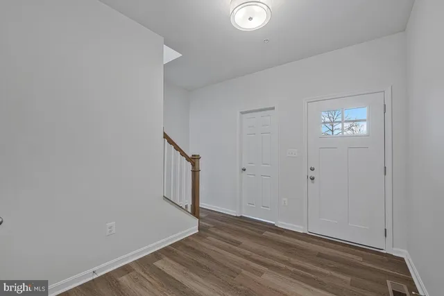 a view of a hallway with wooden floor and staircase