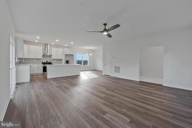 a view of hallway with stairs and wooden floor