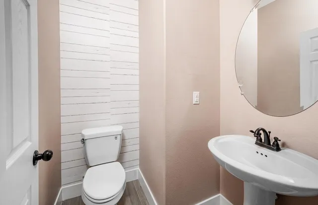 a bathroom with a sink a toilet and mirror
