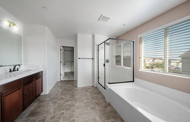 a bathroom with a tub sink and mirror