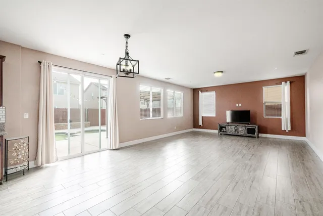 a view of empty room with wooden floor and fireplace