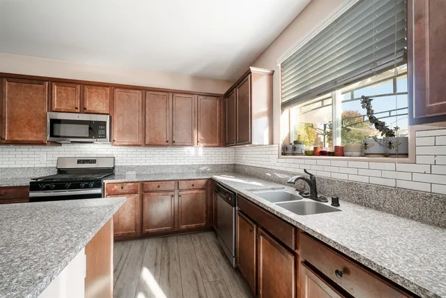 a kitchen with sink a microwave a stove and cabinets