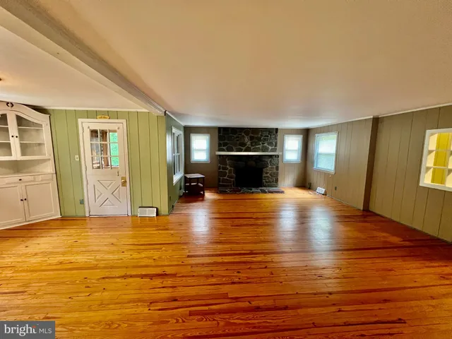 a view of empty room with wooden floor and fireplace