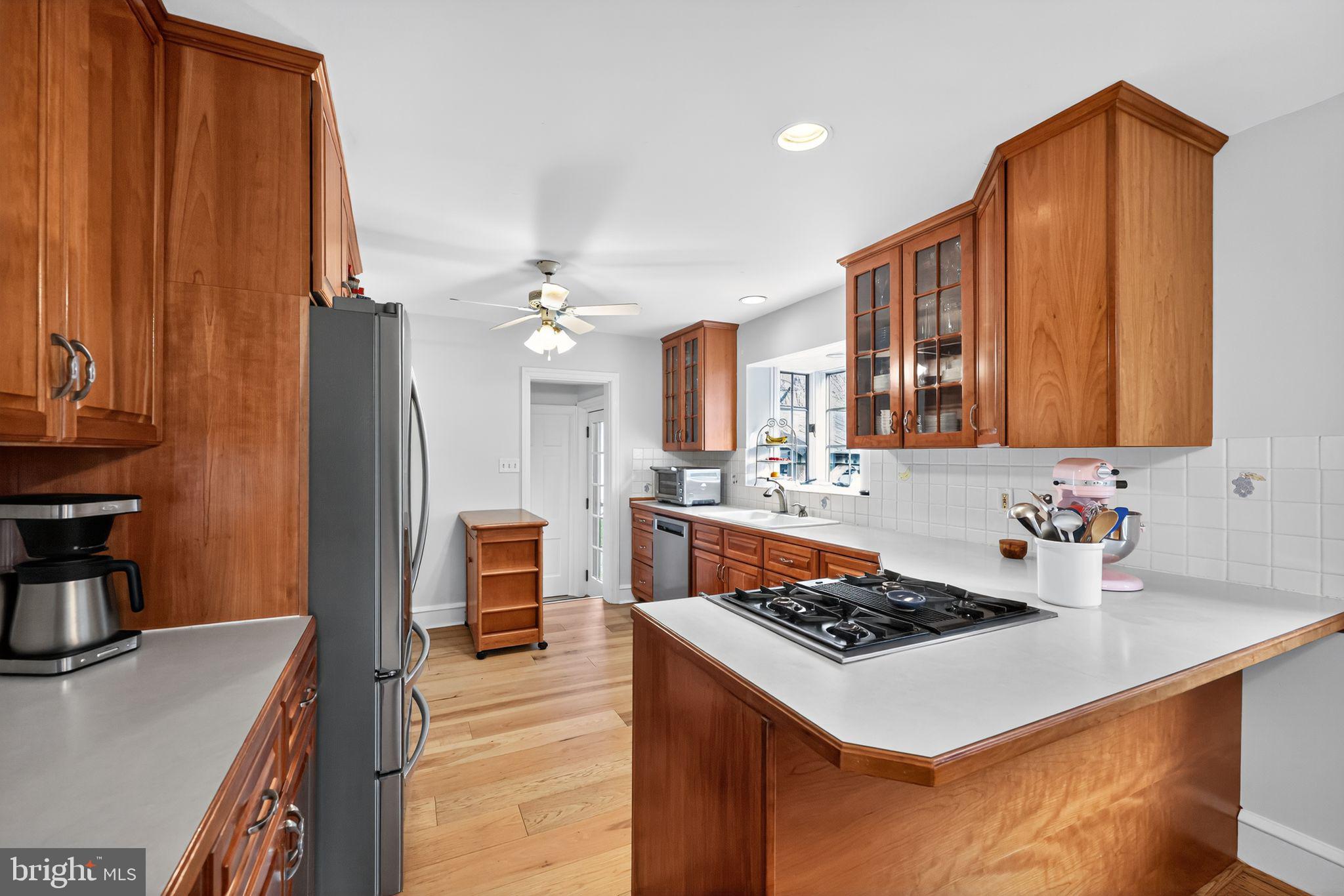 240 Hopkins Avenue Haddonfield, NJ 08033 - Photo 8 of 36 a kitchen with a stove a sink dishwasher and a refrigerator with wooden floor