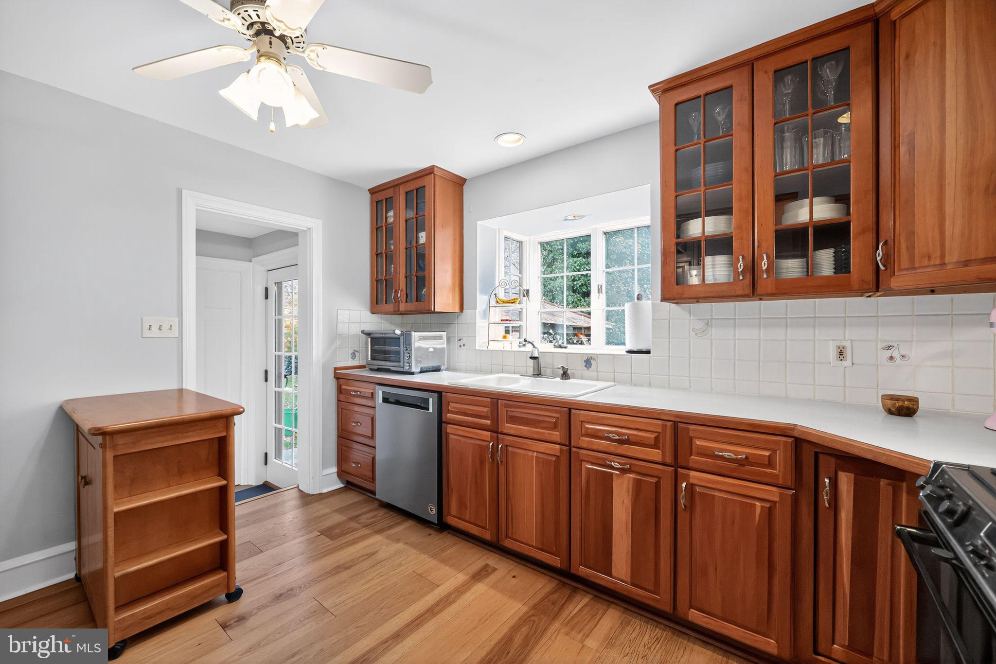 240 Hopkins Avenue Haddonfield, NJ 08033 - Photo 10 of 36 a kitchen with stainless steel appliances granite countertop wooden cabinets a window and a sink