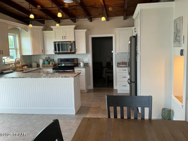 a kitchen with stainless steel appliances granite countertop a stove refrigerator sink and cabinets