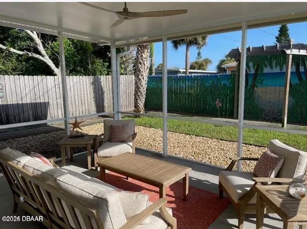 a view of a patio with a table chairs and a backyard