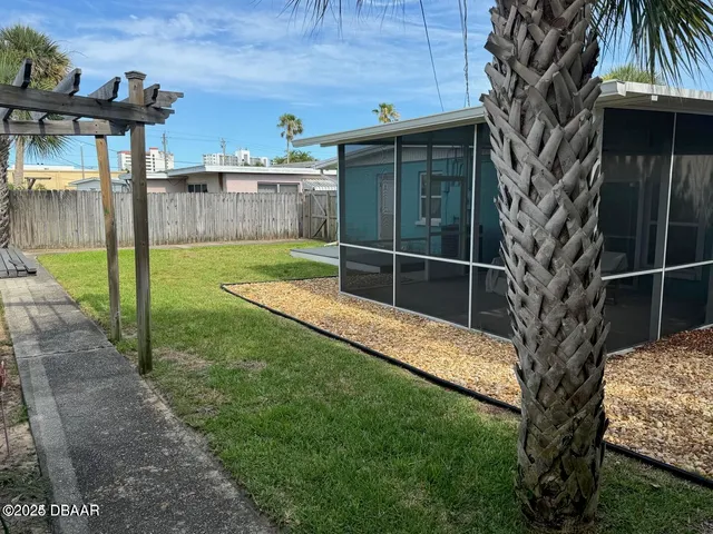 a view of a backyard with plants and a slide