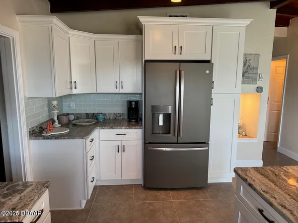a kitchen with stainless steel appliances granite countertop a refrigerator a stove and a sink