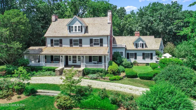a aerial view of a house next to a big yard and large trees