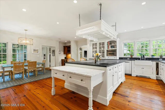 a large kitchen with stainless steel appliances granite countertop a stove and a wooden floors