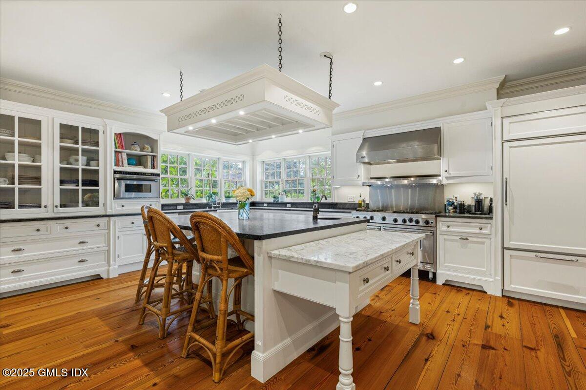 203 Riverside Avenue Riverside, CT 06878 - Photo 13 of 40 a kitchen with stainless steel appliances a table chairs refrigerator and microwave